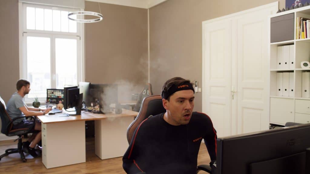 Büro, Typ in Jogginganzug erstaunt am Computer. Dampfwolken schweben um ihn herum
